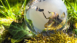 Weltkugel aus Glas, Erde mit Gras und Sonne, Naturschutz, Umweltschutz, Klimaschutz