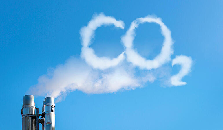 Fabrik stößt Rauch in Form von CO2 in den blauen Himmel