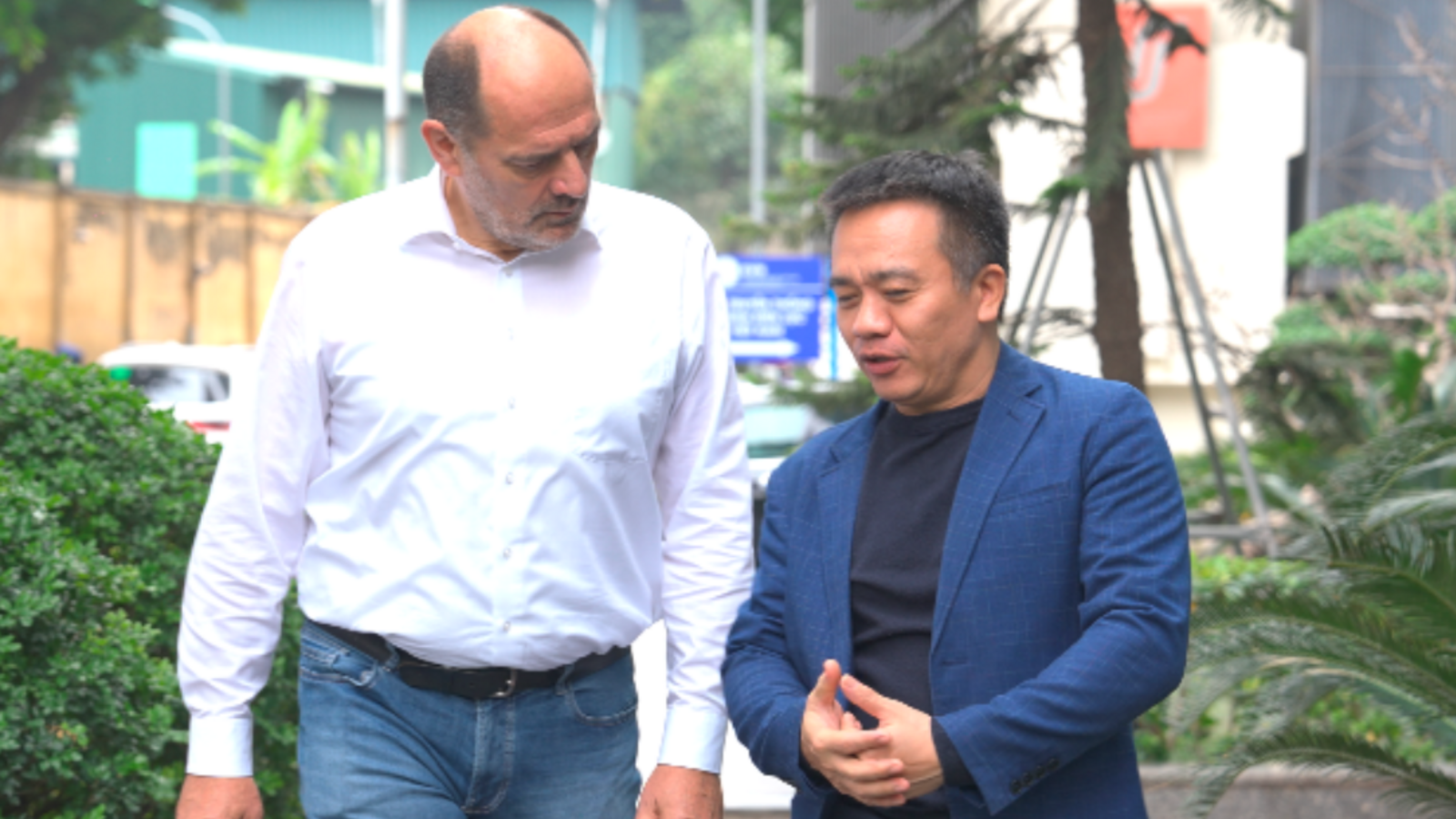 Zwei Männer im Gespräch beim Spaziergang in Vietnam.